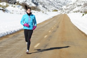 woman running in snow lined road to combat SAD